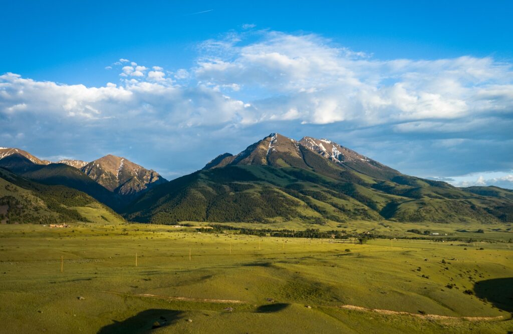 Gorgeous aerial view of tall mountains in the Paradise Valley in Montana under a bright cloudy sky